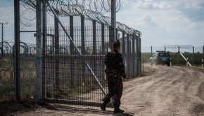 Egy katona a kaput zárja be a járőrautó behajtása után a magyar-szerb határon álló biztonsági határzáron, Kübekházánál. MTI Fotó: Ujvári Sándor